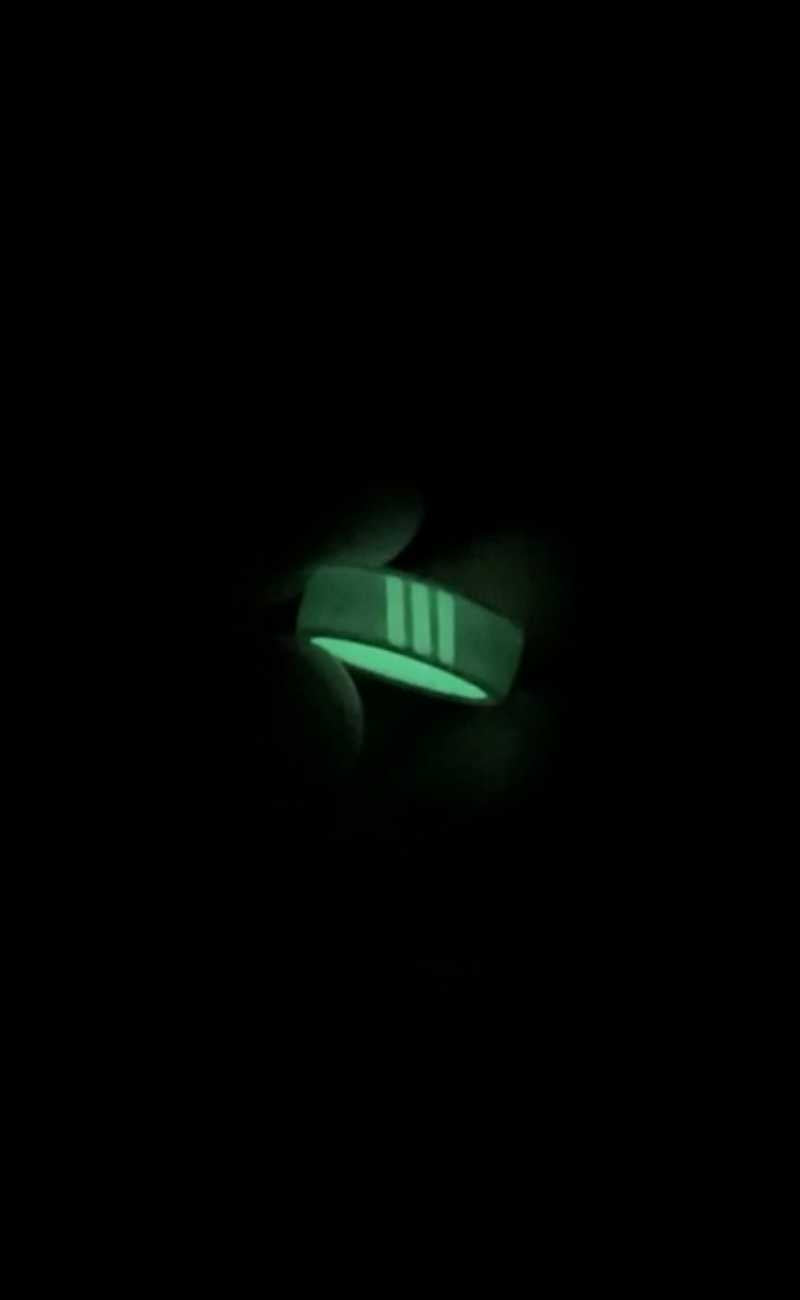 a person holding a silicone ring that is glowing in the dark. 