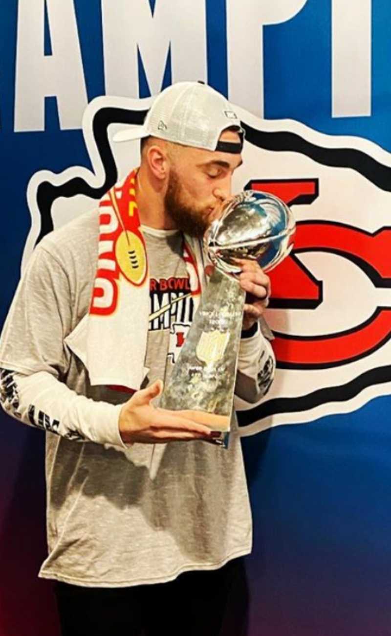 male athlete holding a trophy wearing silicone rings. 