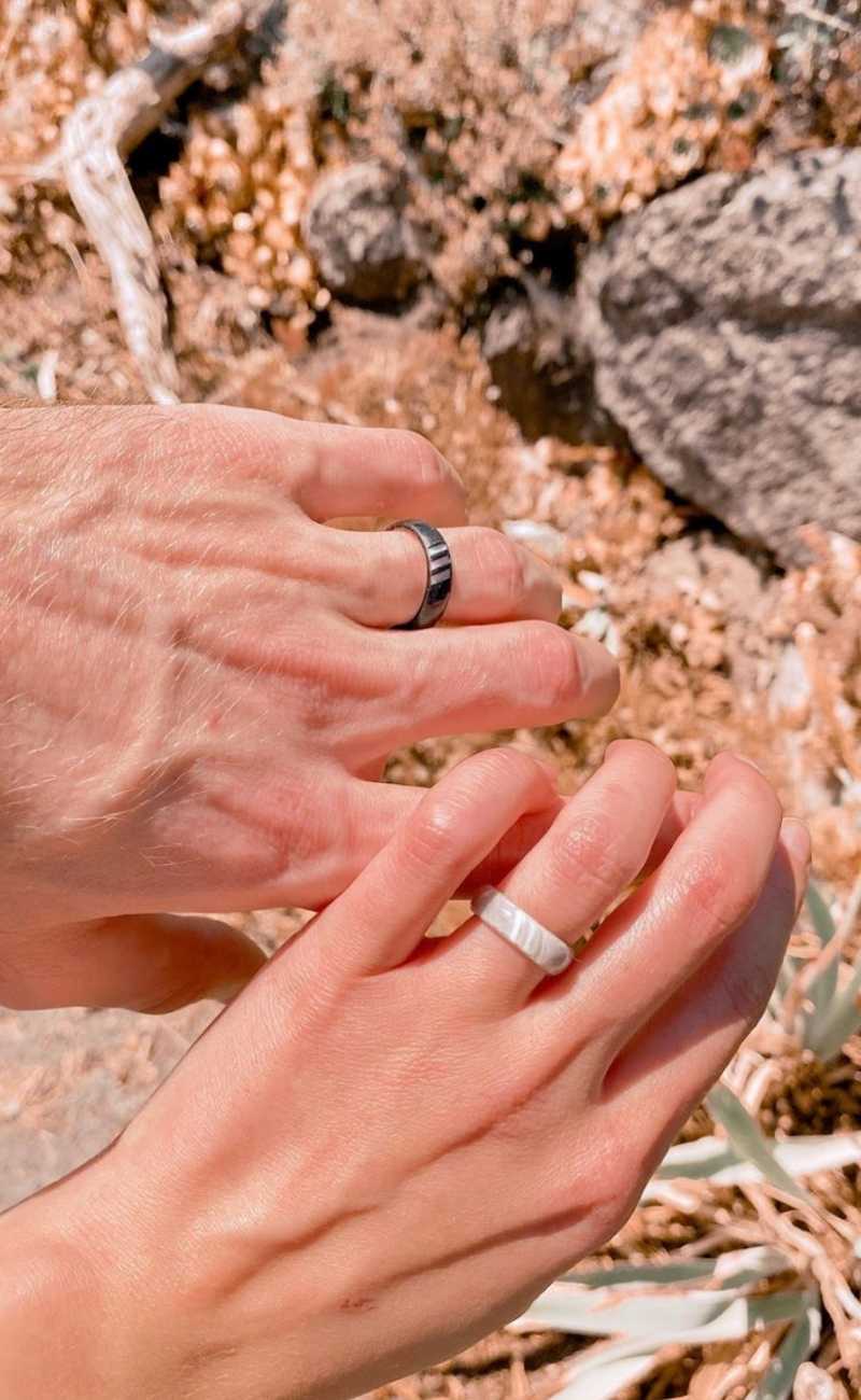 a couple holding their hands out showing their silicone rings.