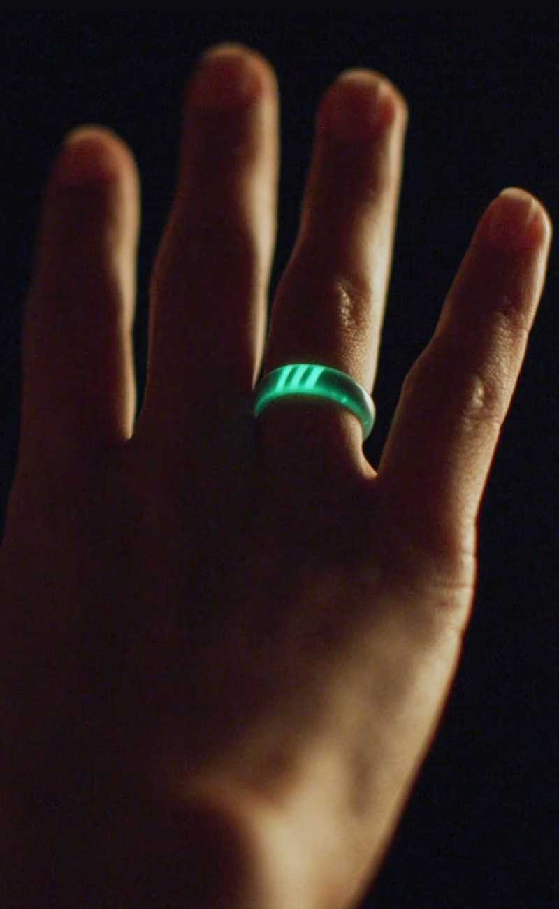 hand in the air wearing a silicone ring that glows in the dark.