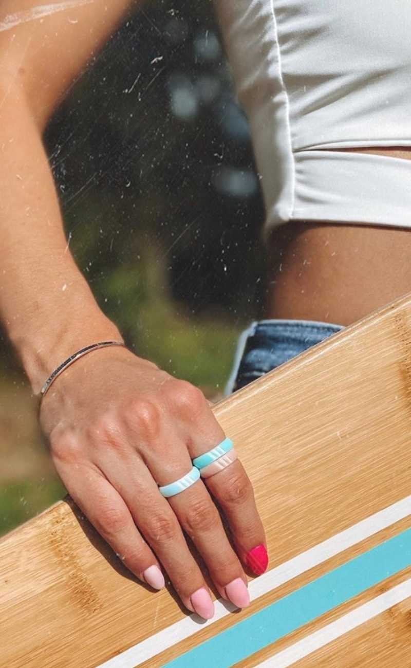 women holding a skateboard wearing silicone rings. 