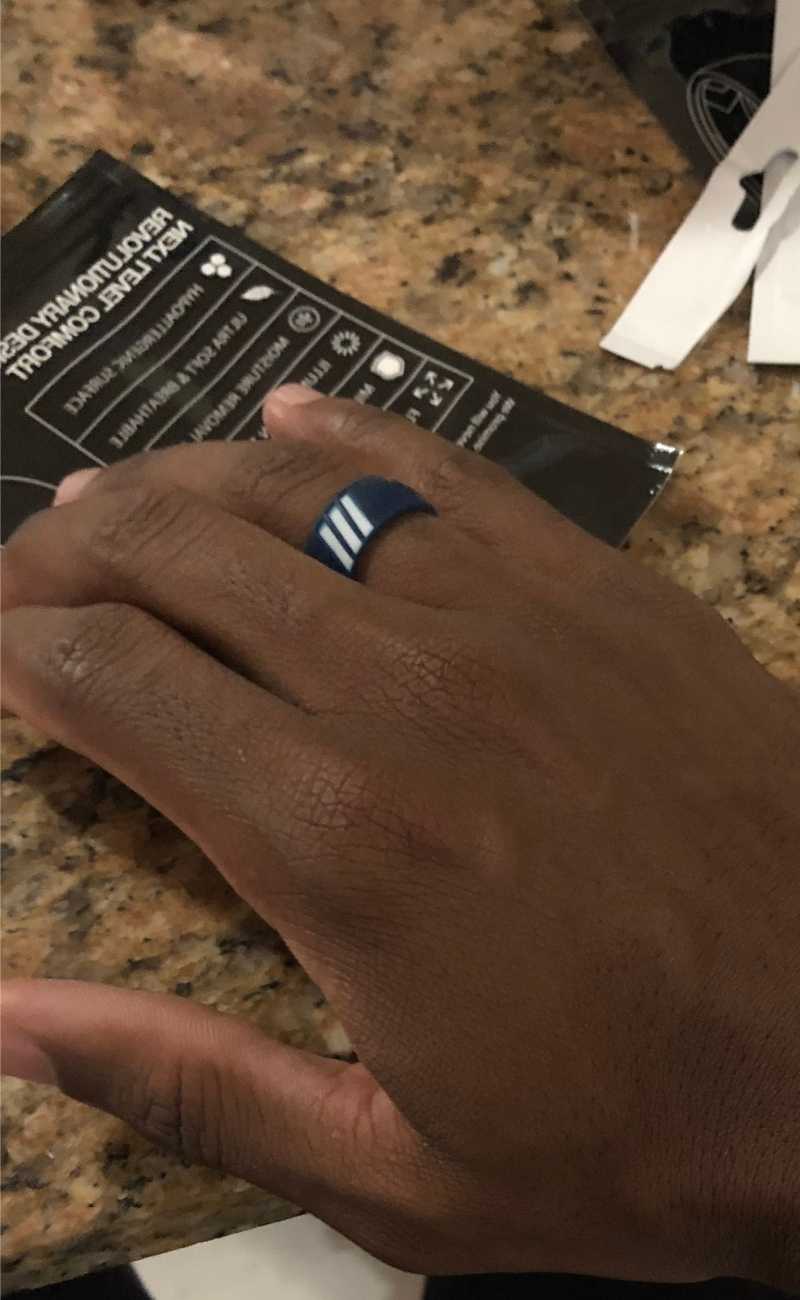a mans hand on a table wearing silicone rings. 
